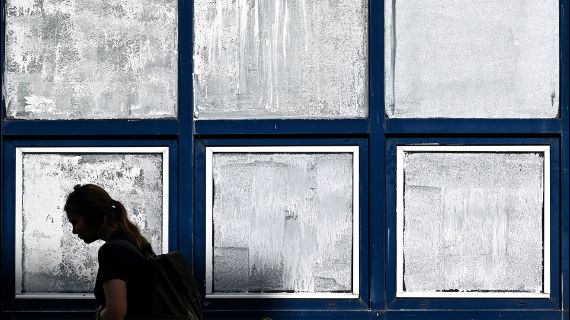 Person walks past windows that have been painted with chalk